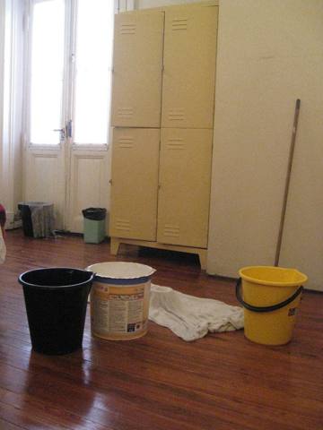 buckets catching water from above, wet floor