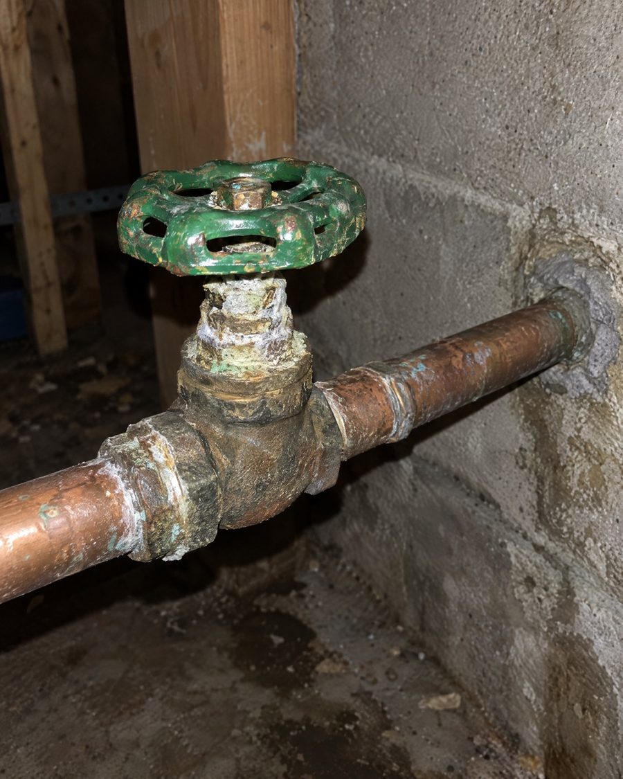 Stand-in picture: indoor copper water line with a green-handled shut-off valve