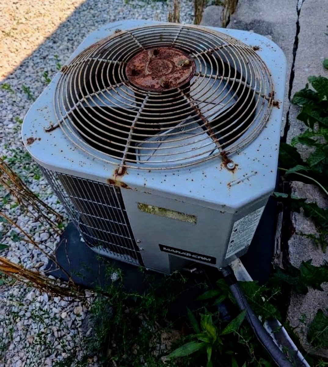 Central AC Condenser — the engine located rusted fan grille and condenser housing on this photograph