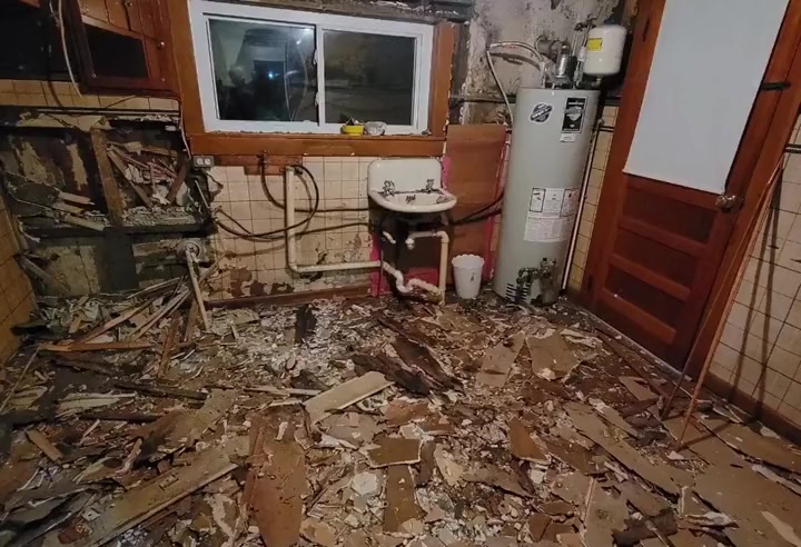 The same room torn out, debris across the floor