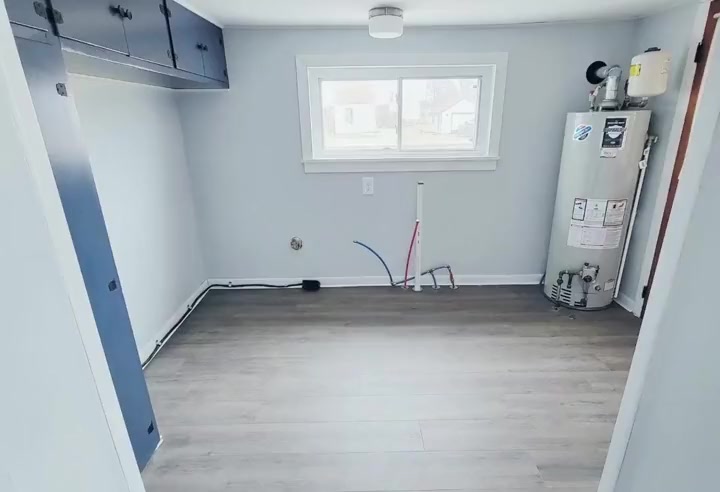 The finished room: new floor, white walls, water heater in place