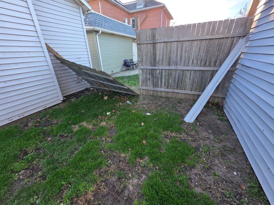 Tenant photo: a wooden fence fallen against a building