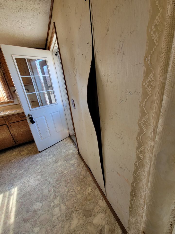 Tenant photo: a split wall panel beside a door